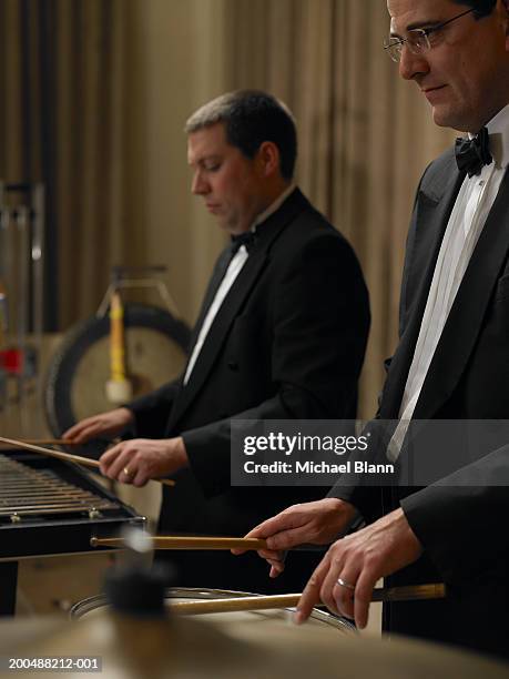 male percussionists performing in orchestra, side view - slaginstrument stockfoto's en -beelden