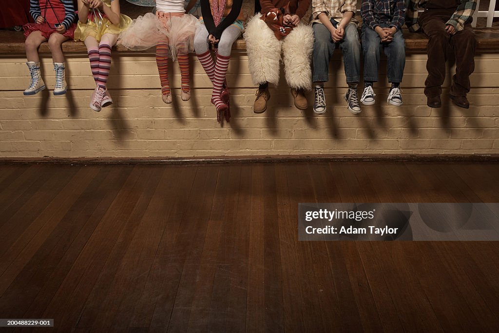 Crianças (menores de 5 a 12 anos) sentada na borda do teatro de palco, parte inferior