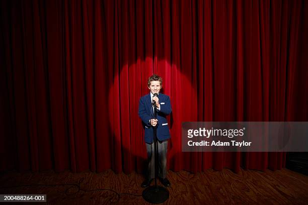 spotlight on on boy (11-13) holding microphone on stage, portrait - emcee bildbanksfoton och bilder