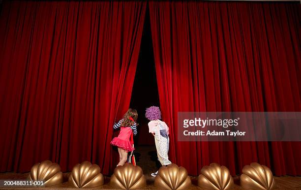 girl and boy (5-7) on stage, looking through curtains, rear view - 怯場 個照片及圖片檔