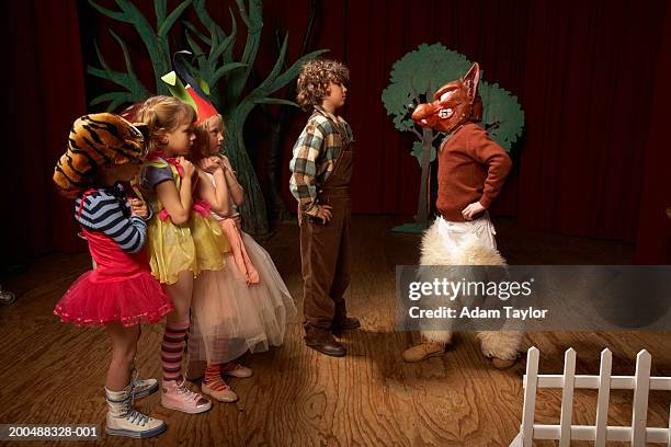 children (5-12) acting on stage, one boy confronting bad wolf - acting fotografías e imágenes de stock