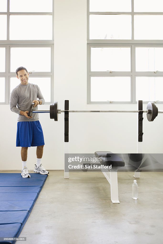 Man putting weight in barbell