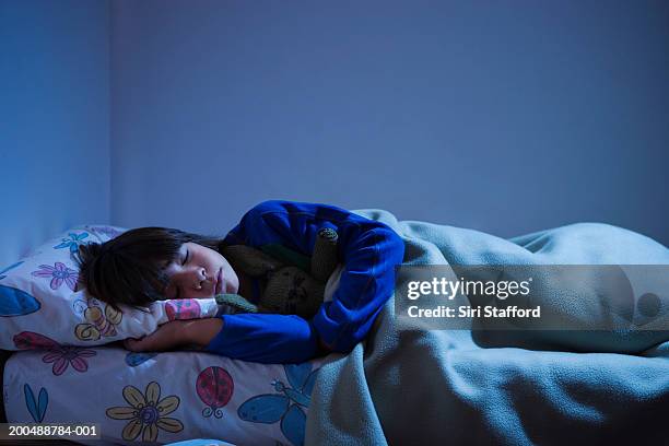 boy (8-10) sleeping in bed - sleeping boys stockfoto's en -beelden
