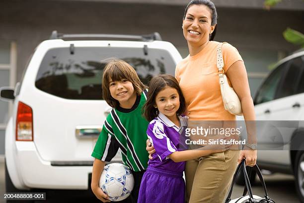 mother with children (6-10) dressed in soccer uniforms - soccer mum stock-fotos und bilder