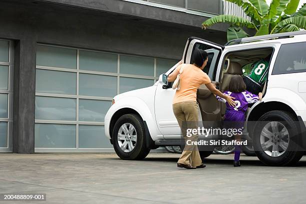 mother getting children into car - girl rising stock pictures, royalty-free photos & images