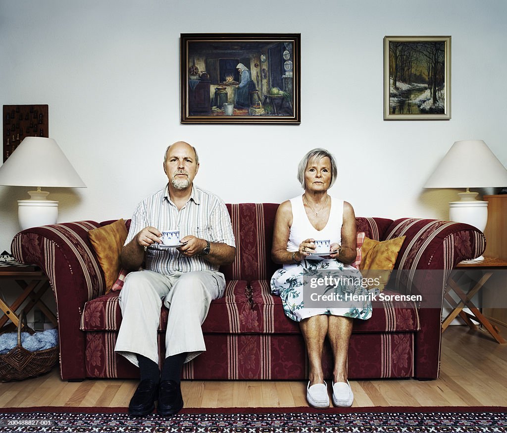 Mature couple sitting on sofa, portrait