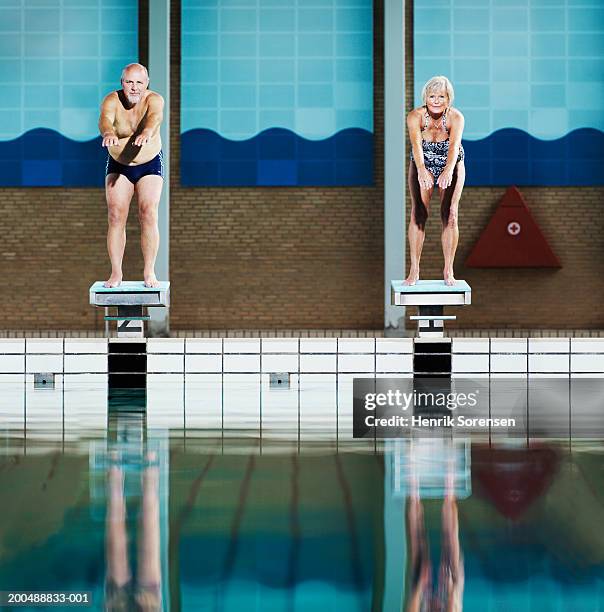 mature couple on diving boards in swimming pool, portrait - old people diving stock pictures, royalty-free photos & images