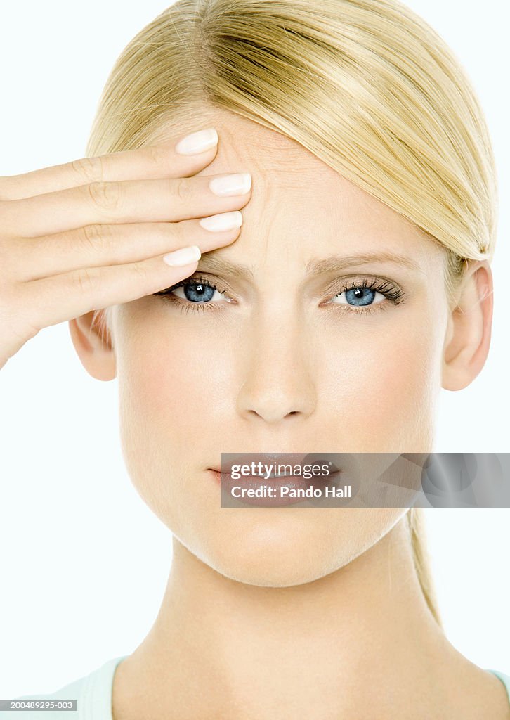 Young woman hand on head, portrait, close-up