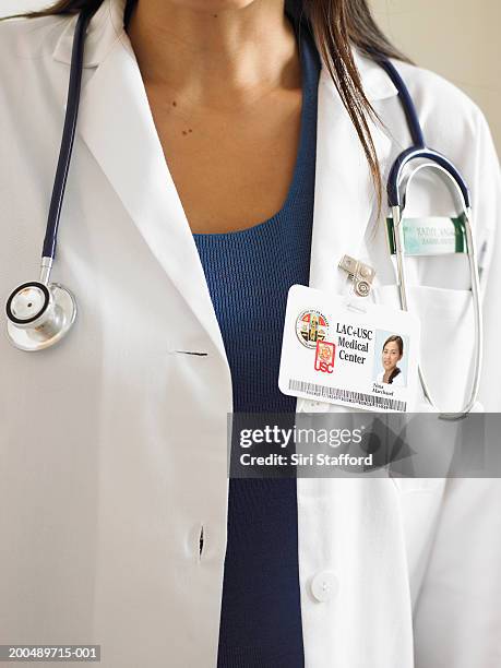 female doctor wearing id badge and stethoscope - id card stockfoto's en -beelden