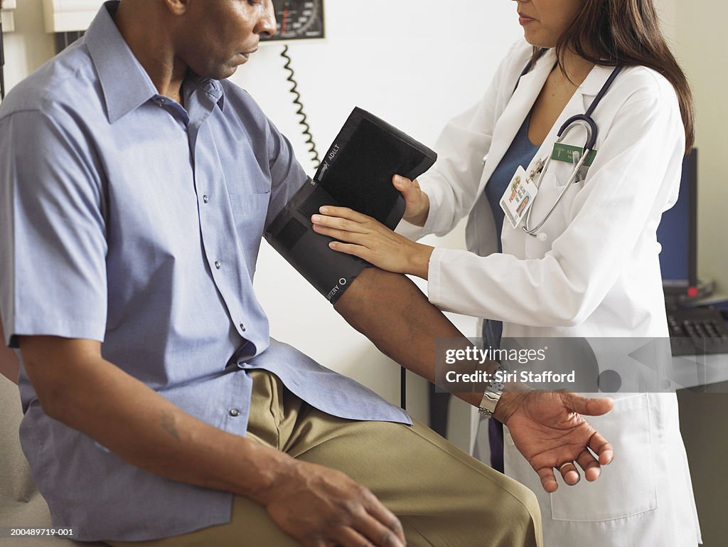 Female doctor taking patient's blood pressure