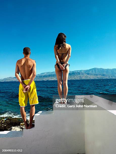 young couple standing on white steps by sea, rear view - brac croatia stock pictures, royalty-free photos & images