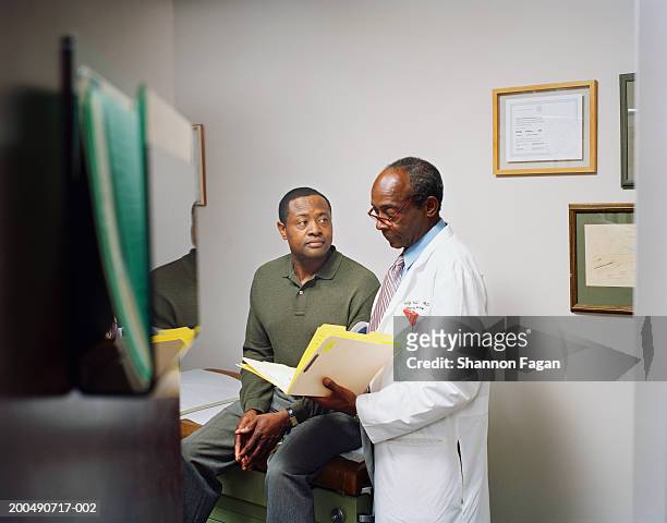 senior male doctor by mature male patient - man talking to doctor stock pictures, royalty-free photos & images