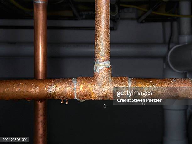 copper plumbing pipe sweating water, close-up - fuoriuscire foto e immagini stock