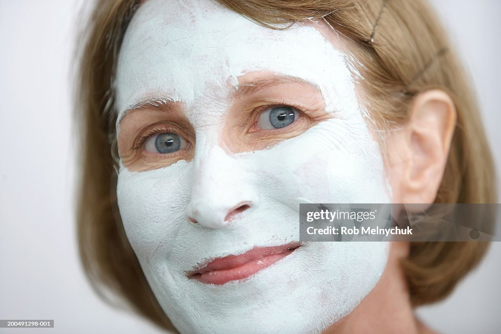 Mature woman wearing facial mask, smiling, portrait