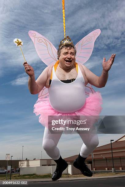man dressed as fairy, hanging in air, portrait - fée photos et images de collection
