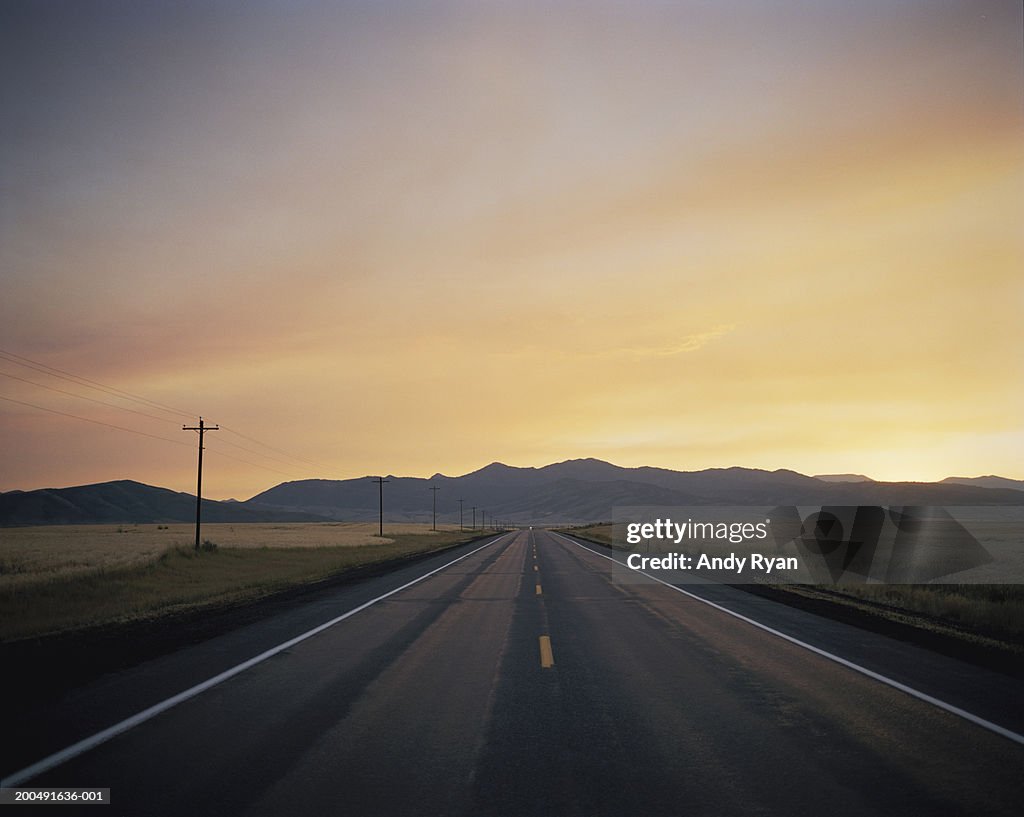 USA, Idaho, straight country road at sunset