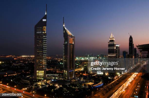 united arab emirates, dubai, skyline, dusk (blurred motion) - emirates towers stock pictures, royalty-free photos & images