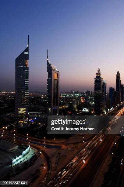 united arab emirates, dubai, skyline, dusk, (blurred motion) - emirates towers stock pictures, royalty-free photos & images