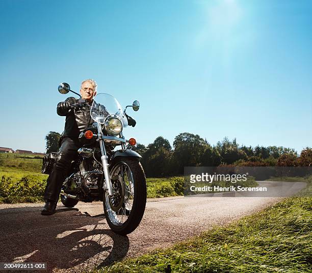 senior man on motorbike, parked across road, portrait, low angle view - old motorcycles bildbanksfoton och bilder