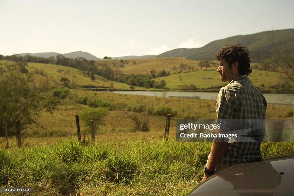 Young man looking at field, side view