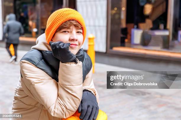 a smiling teenage boy looking at camera while standing on a walking street - stakes day stock pictures, royalty-free photos & images