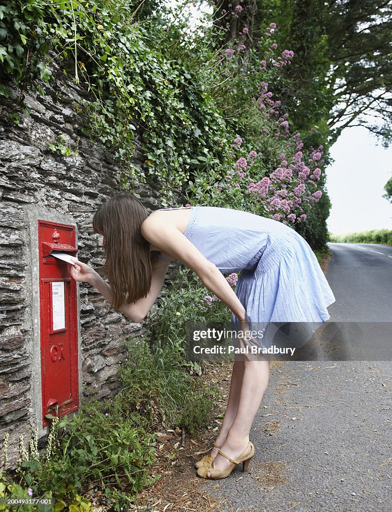 Woman posting letter, close-up, side view