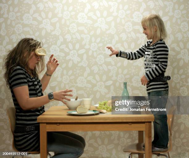 daughter (4-5) throwing food at mother during meal - food fight stock pictures, royalty-free photos & images