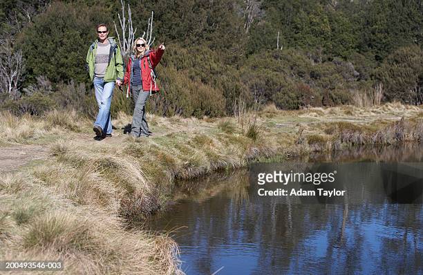 couple in hiking hiking along river bank - hiking tasmania stock-fotos und bilder