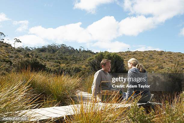 couple sitting on boardwalk, smiling - tasmania food stock pictures, royalty-free photos & images