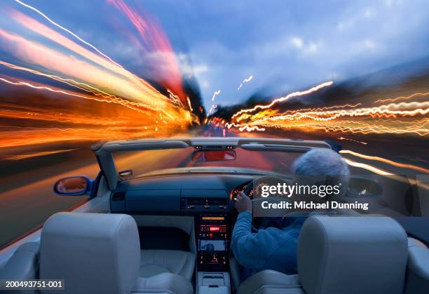 man driving car, dusk, rear view (blurred motion) - man driving sports car stock pictures, royalty-free photos & images