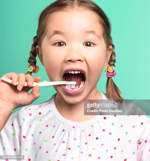girl (5-7) brushing teeth, one tooth missing, close-up, portrait - spotted gum stock pictures, royalty-free photos & images