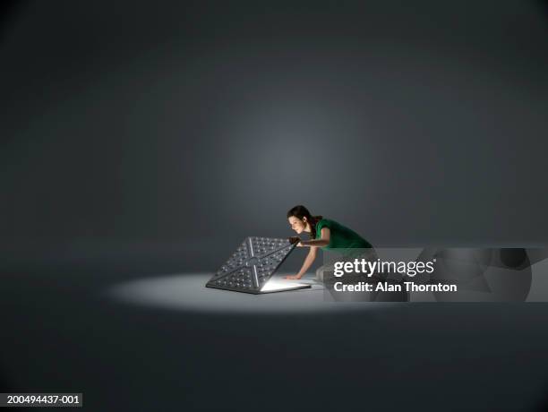 woman looking into manhole in spotlight - manhole stock pictures, royalty-free photos & images