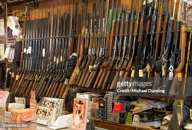 guns on rack in store, close-up - vuurwapen stockfoto's en -beelden