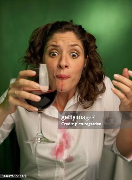 young woman with spilt red wine on mouth and shirt - wine stain imagens e fotografias de stock