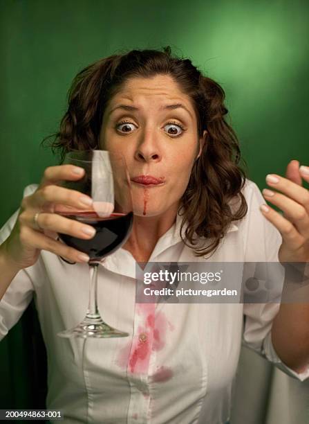 young woman with spilt red wine on mouth and shirt - wine stain 個照片及圖片檔