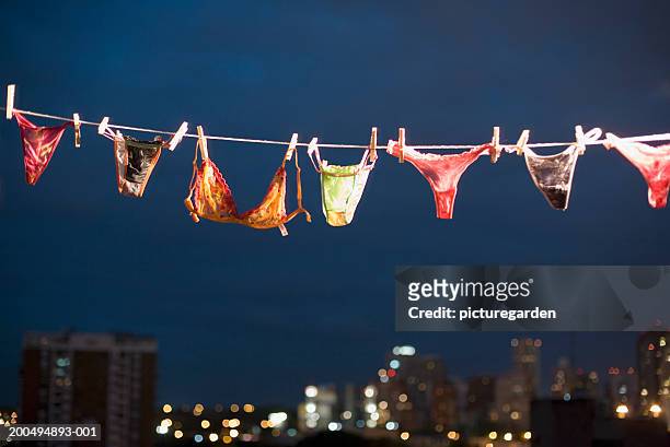 women's underwear hanging on line, night - thongs stock-fotos und bilder