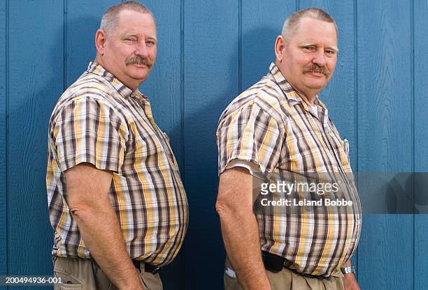 senior male twins wearing matching checked short sleeved shirts - twin stock pictures, royalty-free photos & images