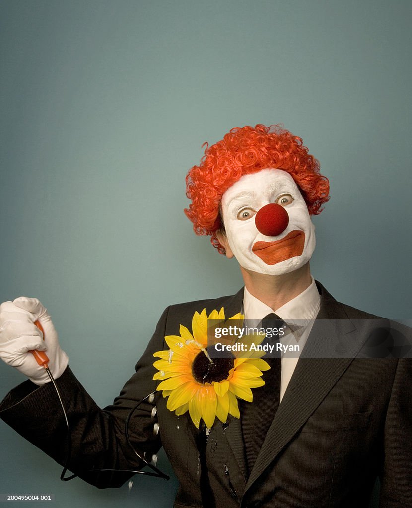 Businessman dressed as clown squirting water from novelty flower