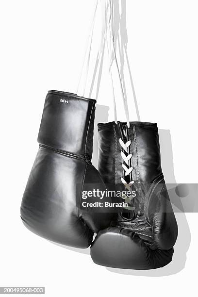 boxing gloves hanging against white background, close-up - boxing glove stockfoto's en -beelden