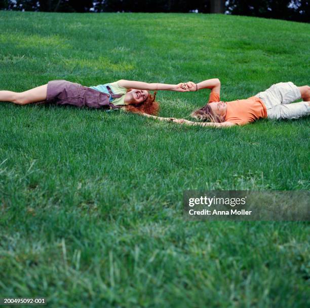 teenage couple (15-17) holding hands, rolling down hill - rolling fotografías e imágenes de stock