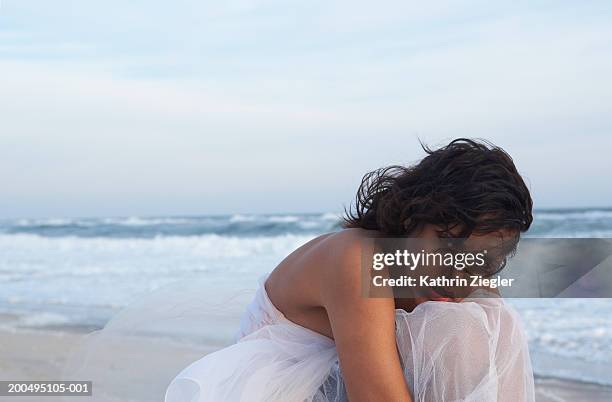 young woman sitting on beach, portrait - strapless evening gown stock pictures, royalty-free photos & images