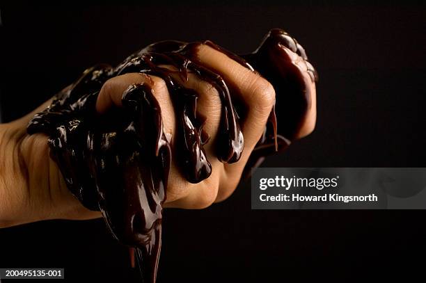 young man squeezing melted chocolate, close-up of hand - chocolate drip stock pictures, royalty-free photos & images