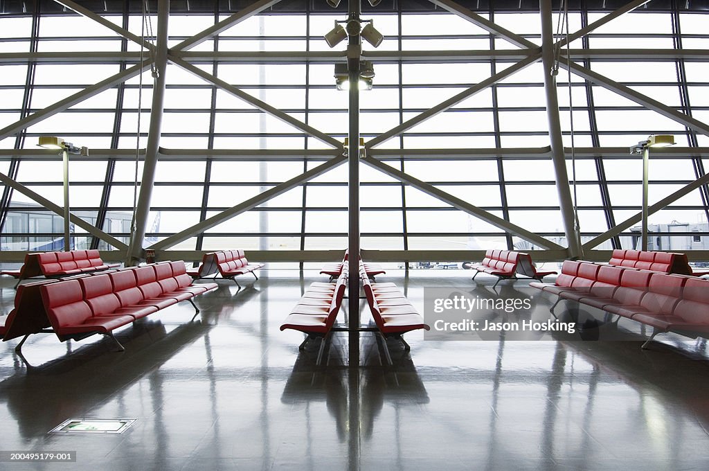 Empty chairs in airport departure gate area