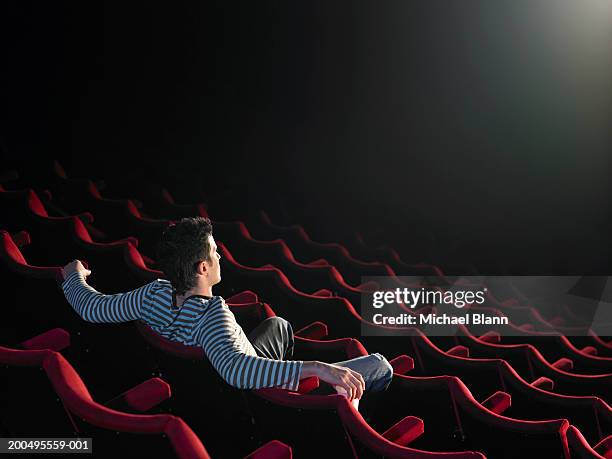 man sitting in empty cinema - kinosaal stock-fotos und bilder