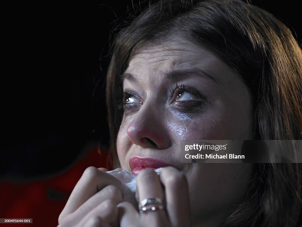 Woman in cinema crying, close-up