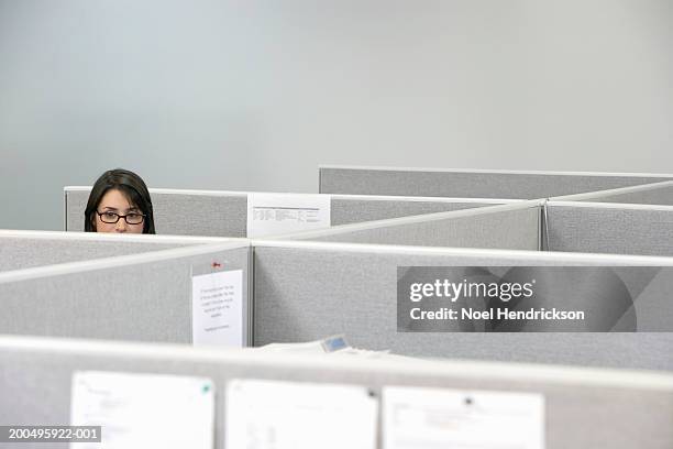 young businesswoman sitting in cubicle, high section - office cubicle stock-fotos und bilder