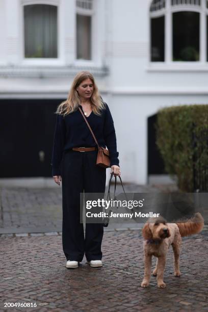 Britta Becker seen wearing OH OK Studio gold zodiac necklace, Twelve by Britta Becker navy blue wool knit sweater, Hermès brown leather belt, Twelve...