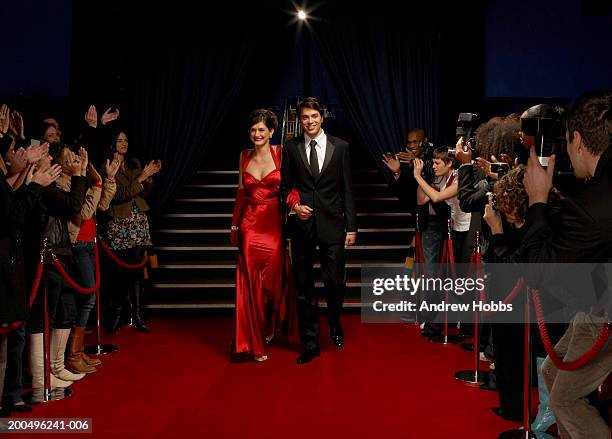 celebrity couple in evening wear walking on red carpet - alfombra roja fotografías e imágenes de stock