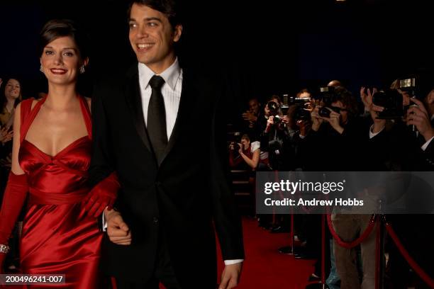 celebrity couple in evening wear walking on red carpet - red carpet paparazzi stock pictures, royalty-free photos & images