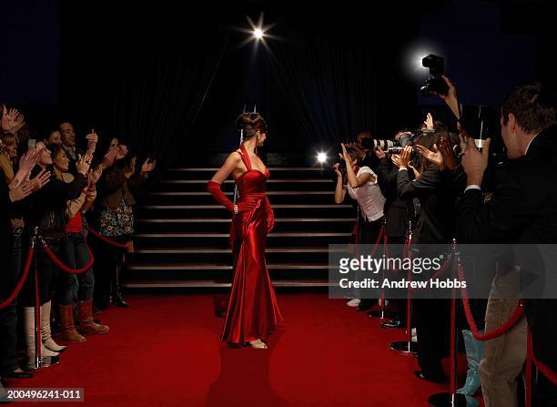 female celebrity in evening  dress posing for paparazzi on red carpet - satin dress stock pictures, royalty-free photos & images